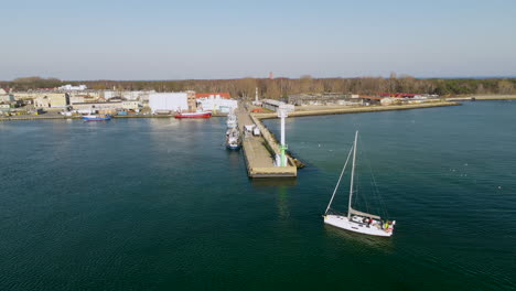 aerial shot of sailing boat arrving port of peninsula hel during sunny day in poland