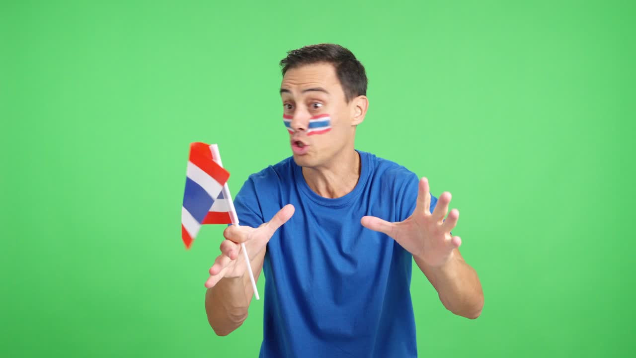 Man cheering for Thailand screaming and waving a national flag