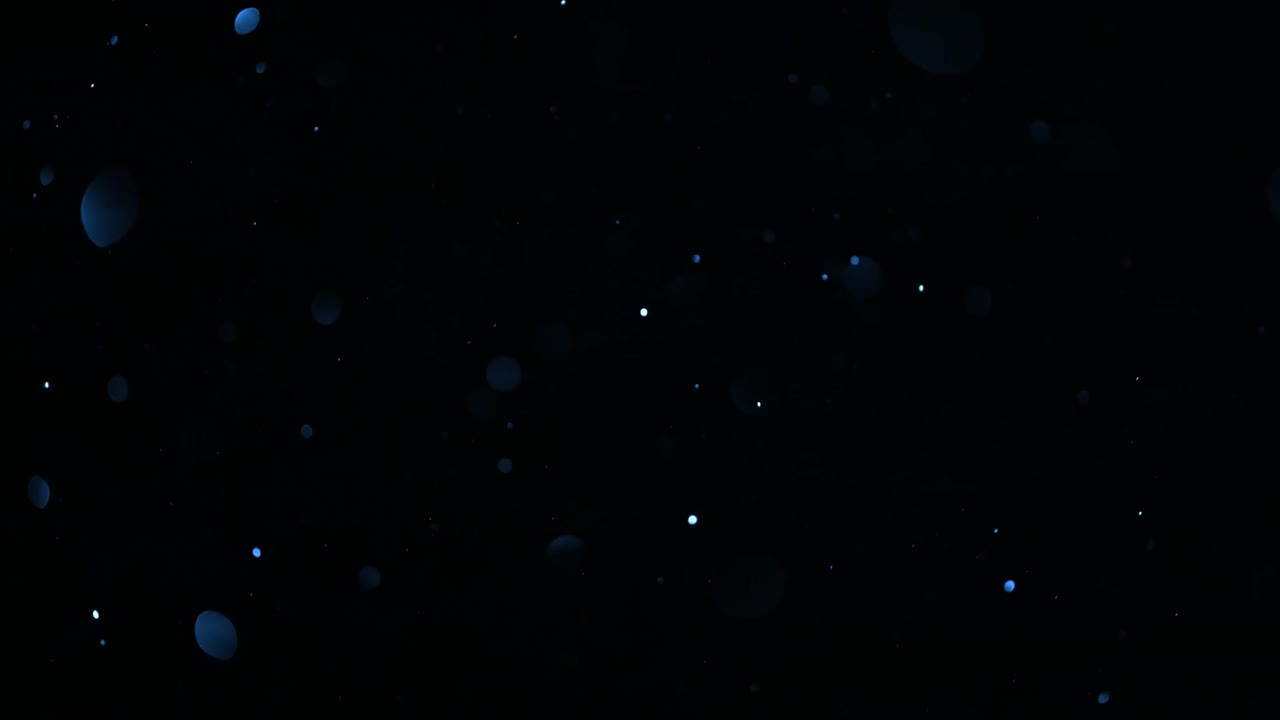 Abstract Blue and White Bokeh Particles Floating on Black Background
