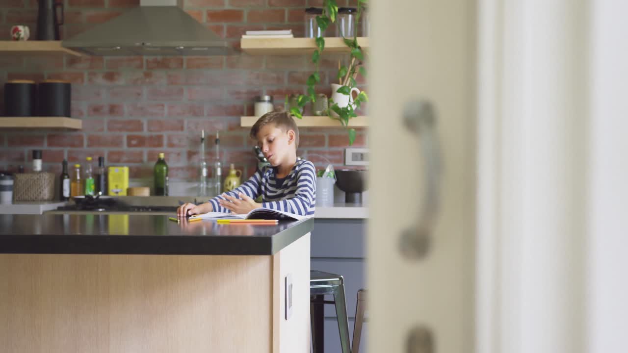 niño estudiando en la mesa en la cocina en casa 4k