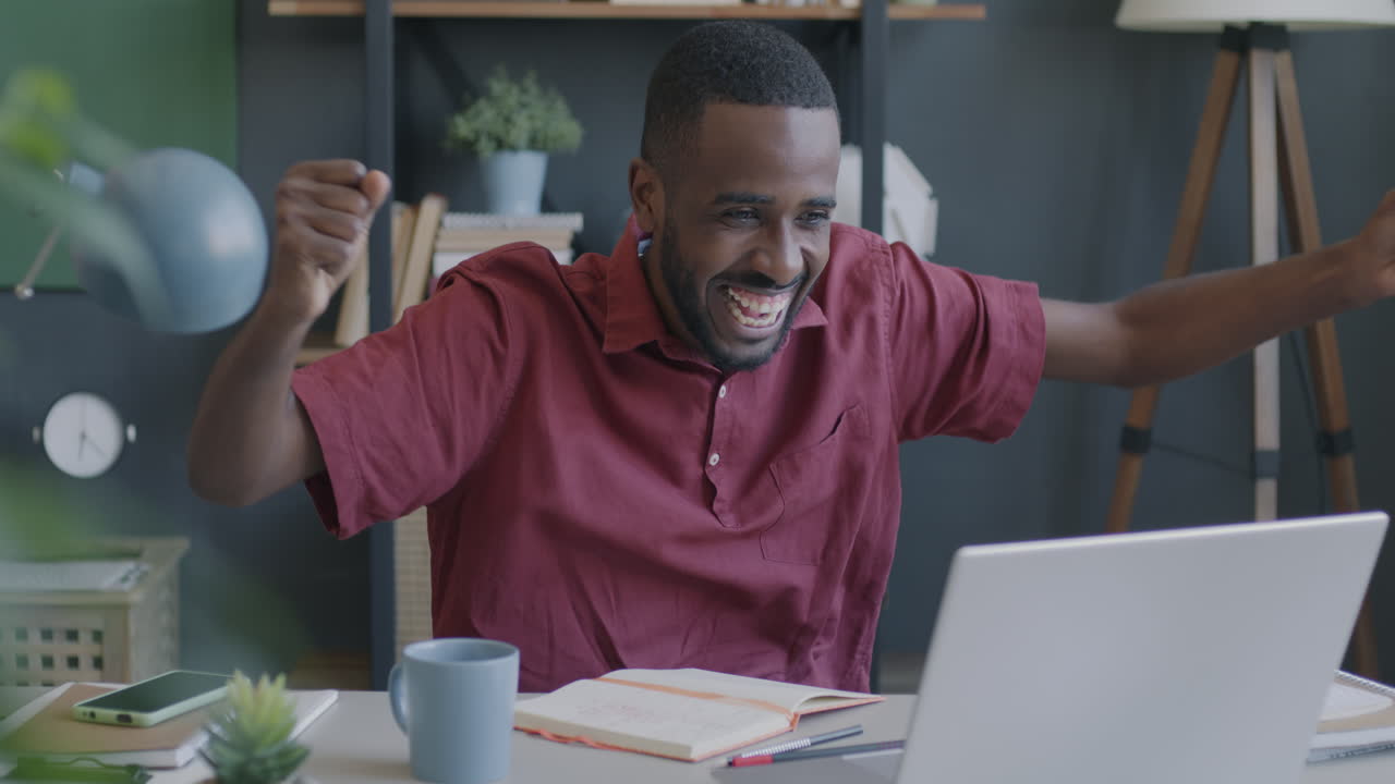 Uomo felice che celebra il successo nel suo home office.