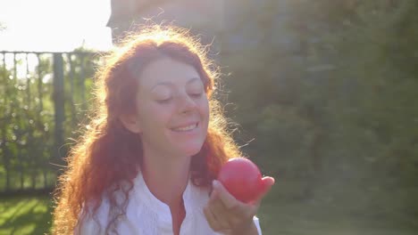 woman enjoying a red fruit outdoors
