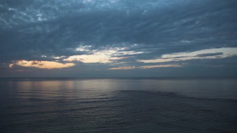 sunset above the sea with boat moving over time-lapse