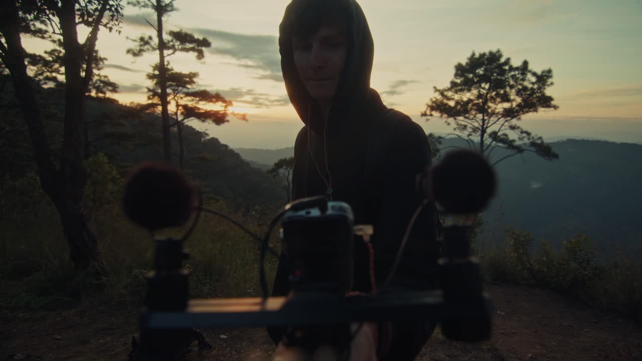 Vlogger recording video at sunset in mountain forest
