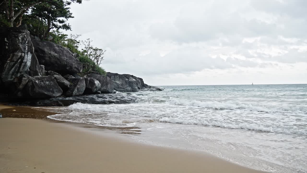 Cinematic shot Of Sea Waves Breaking On The Rocks and sand