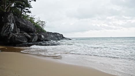 Cinematic-shot-Of-Sea-Waves-Breaking-On-The-Rocks-and-sand