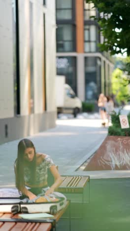 young woman packing luggage outdoors