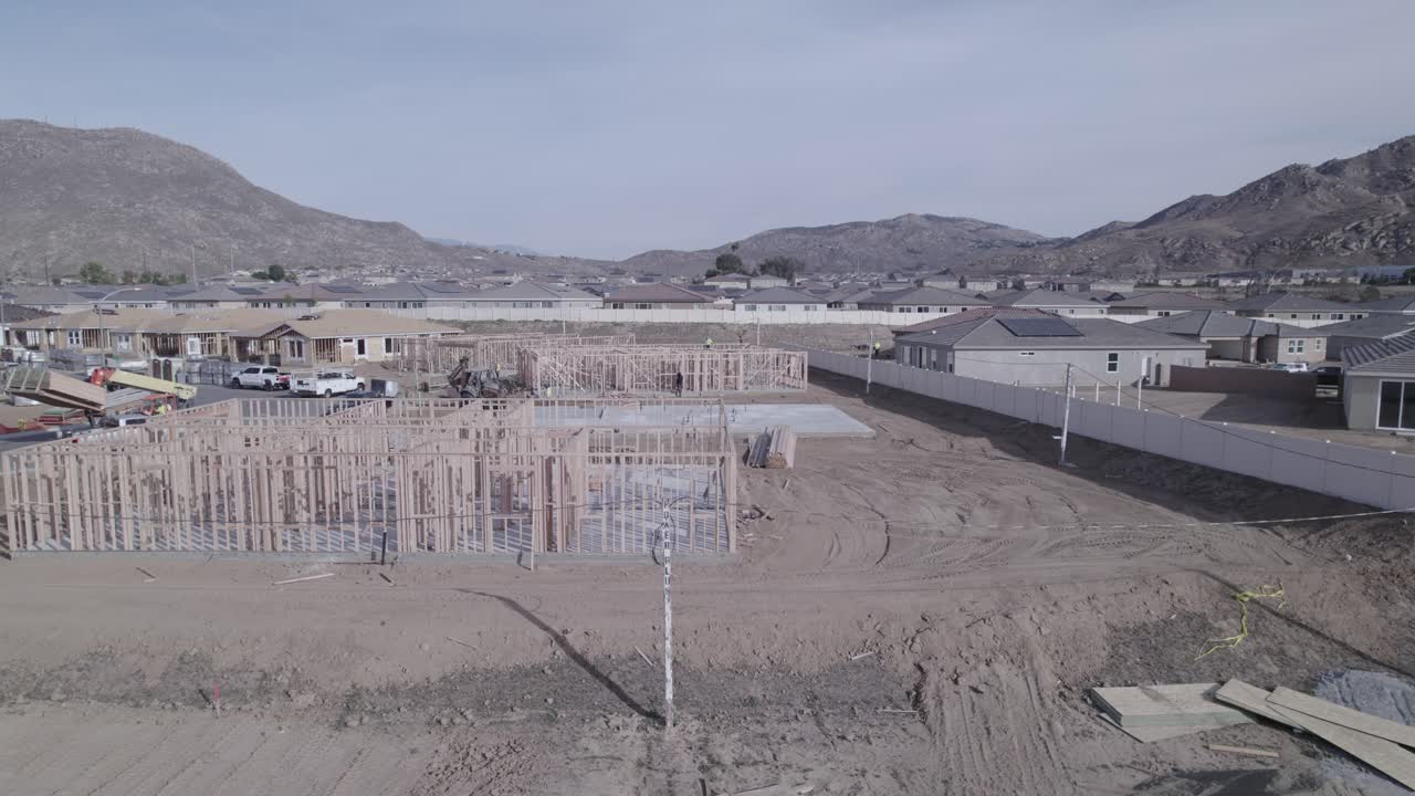 un dron se acerca gradualmente a una casa parcialmente construida, con sólo los marcos de las paredes levantadas