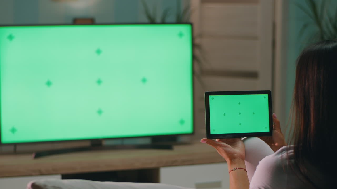 Woman watching TV and tablet at home