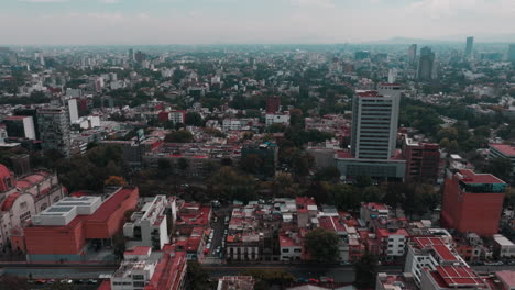 Drone-footage-of-Mexico-City-showcasing-highways,-streets,-cars,-homes,-and-distant-mountains-against-the-skyline