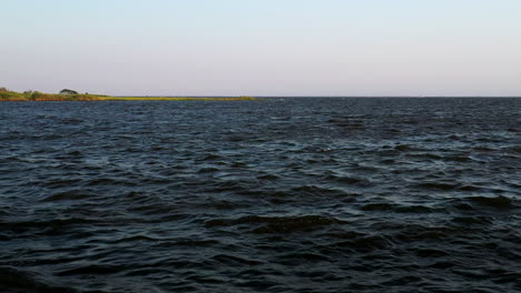 Niedrige-Luftaufnahme-Einer-Drohne,-Die-Stetig-über-Dem-Wasser-Des-East-Islip-Marina-Schwebt---Park-Mit-Blick-Auf-Das-Sumpfgebiet-Bei-Sonnenuntergang