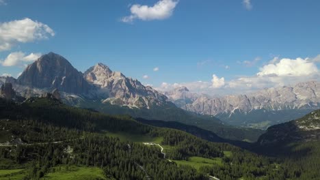 aerial of a perfect green valley surrounded by beautiful mountains in the alps, dolomites, belluno, italy, europe