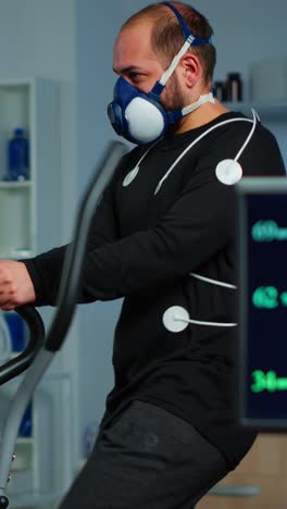 man undergoes a fitness test with a respiratory mask and medical sensors