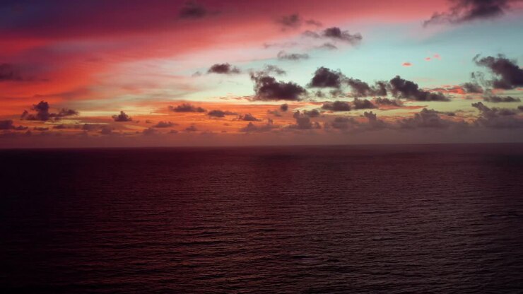 Aerial drone time-lapse of a stunning golden pink and orange sunrise with the vast ocean below on a warm summer morning in Northern Brazil near Joao Pessoa