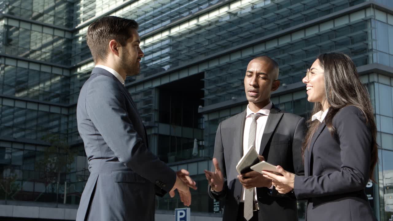 Jeunes collaborateurs professionnels discutant dans la rue