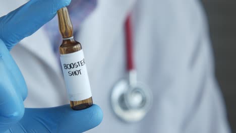 médico con un vial de inyección de refuerzo