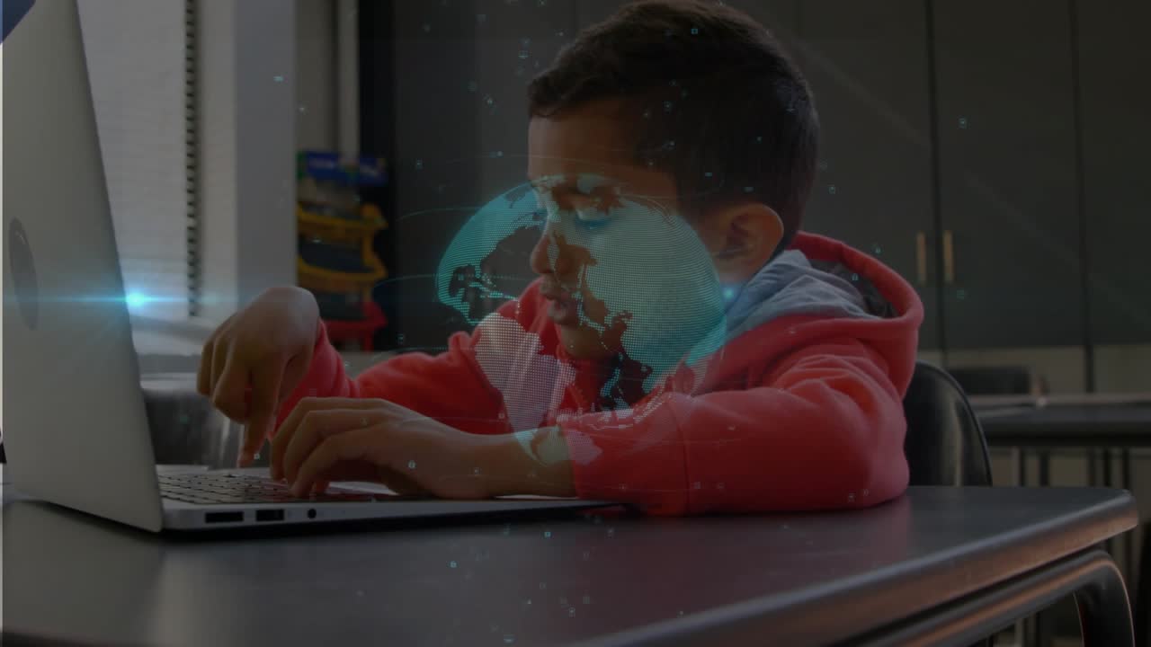 Student boy typing on laptop in classroom, activating faint globe sliding over face for learning