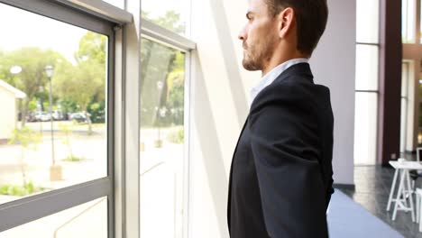 Thoughtful-businessman-looking-through-window-4k