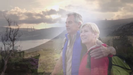 pareja de ancianos caucásicos que caminan por la costa sobre el mar y el barco