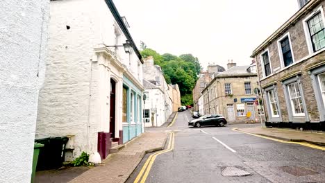 a quaint street scene with shops and cars