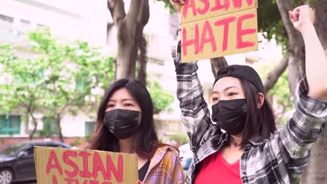 asian women with posters during protest in city