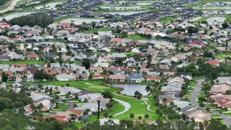 residential community with winding streets and green spaces in the villages, florida. rows of single-family homes line manicured lawns with a golf course view in the foreground. aerial perspective.