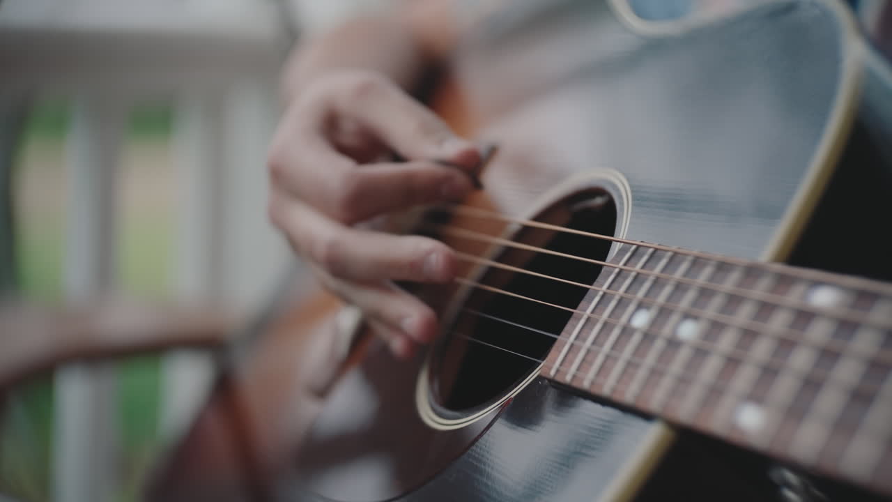 persona que toca una guitarra acústica