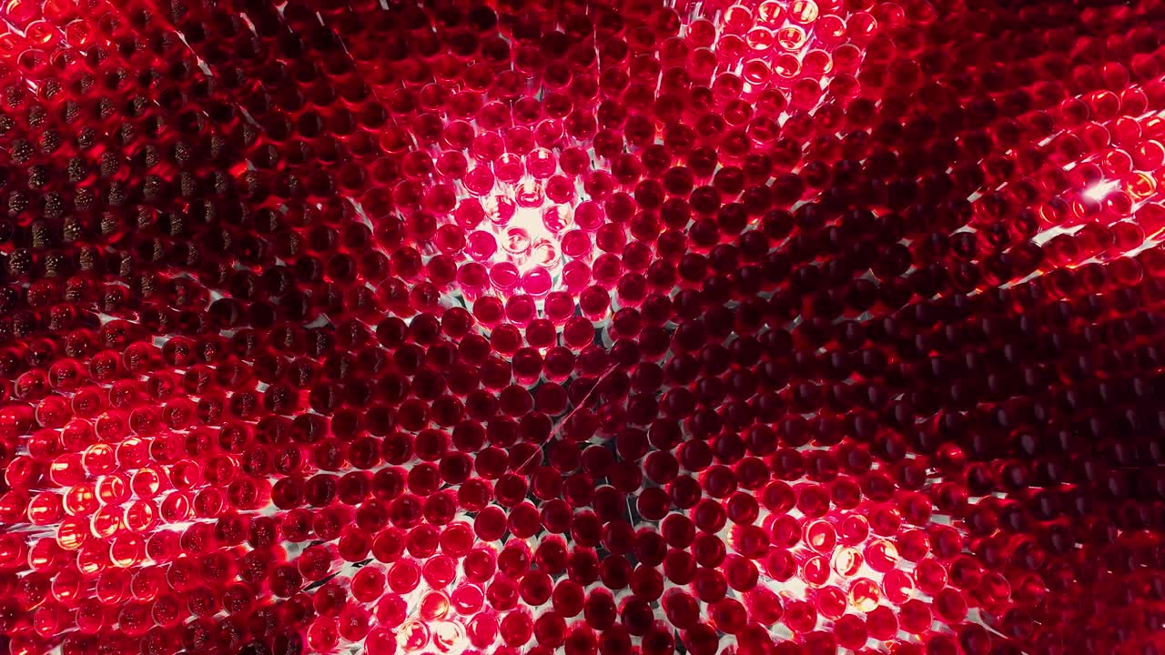 Glass bottles filled with red liquid and hung from the ceiling and lit by lamps. All this beauty is installed in the bar