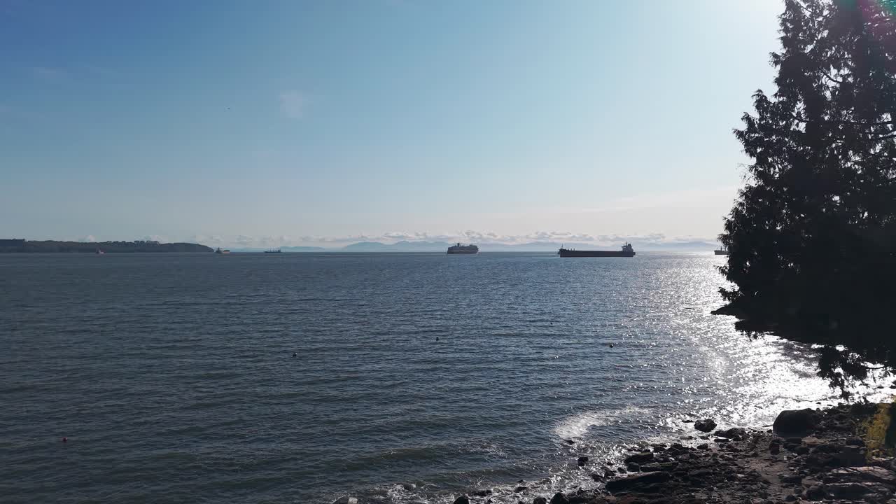 A view of the West Vancouver sea from a luxury home with ships and cruise ships sailing under a clear blue sky