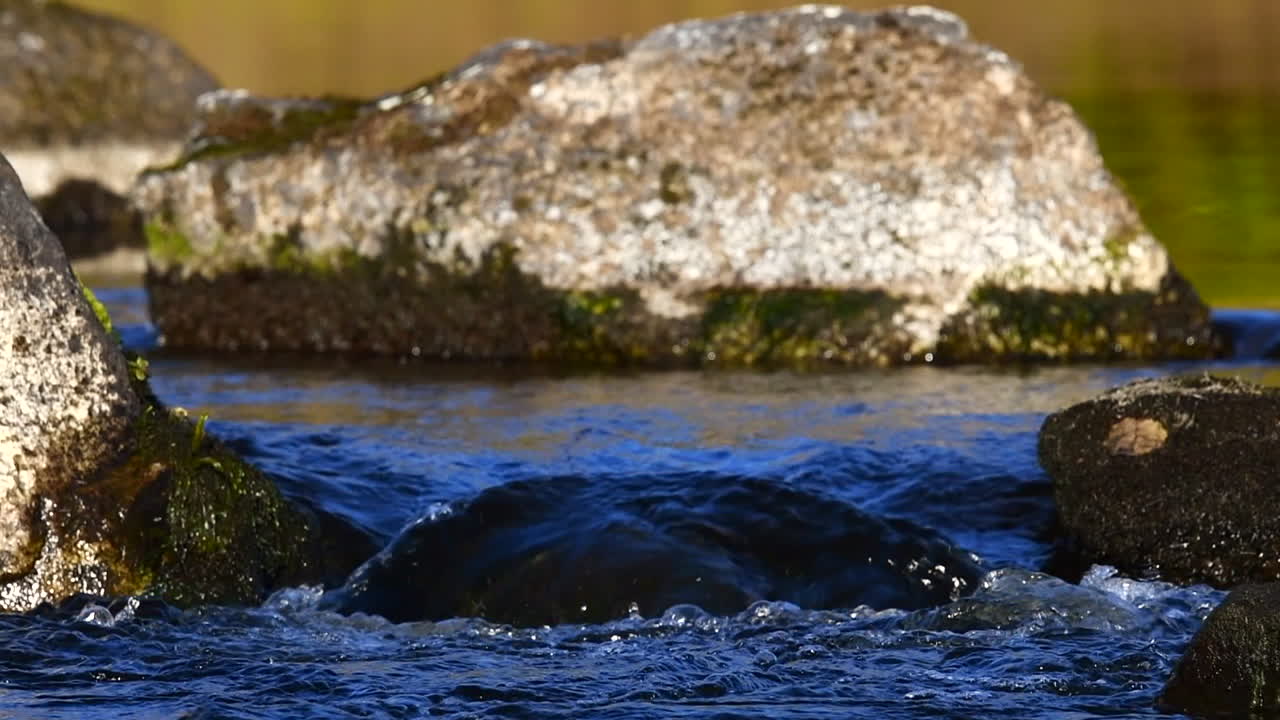 video en cámara lenta de un río que fluye a través de dos rocas