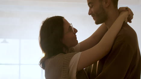 young couple hugging indoors