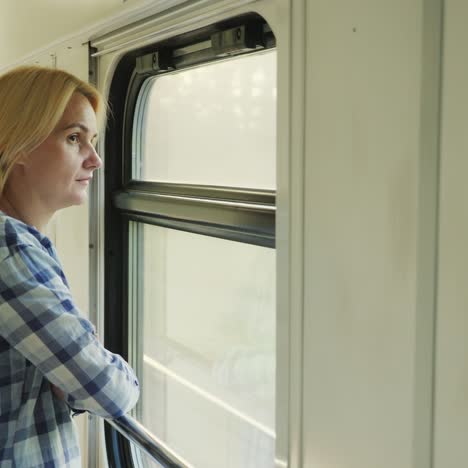 woman traveling on the train looking out the window