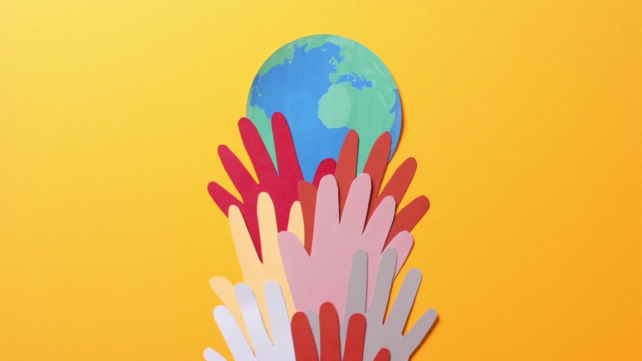 복사 공간이 있는 노란색 배경에 있는 다채로운 종이로 만든 지구와 함께 손을  ⁇ 습니다.