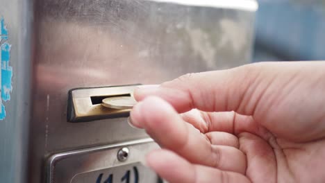 inserting coin into a vending machine