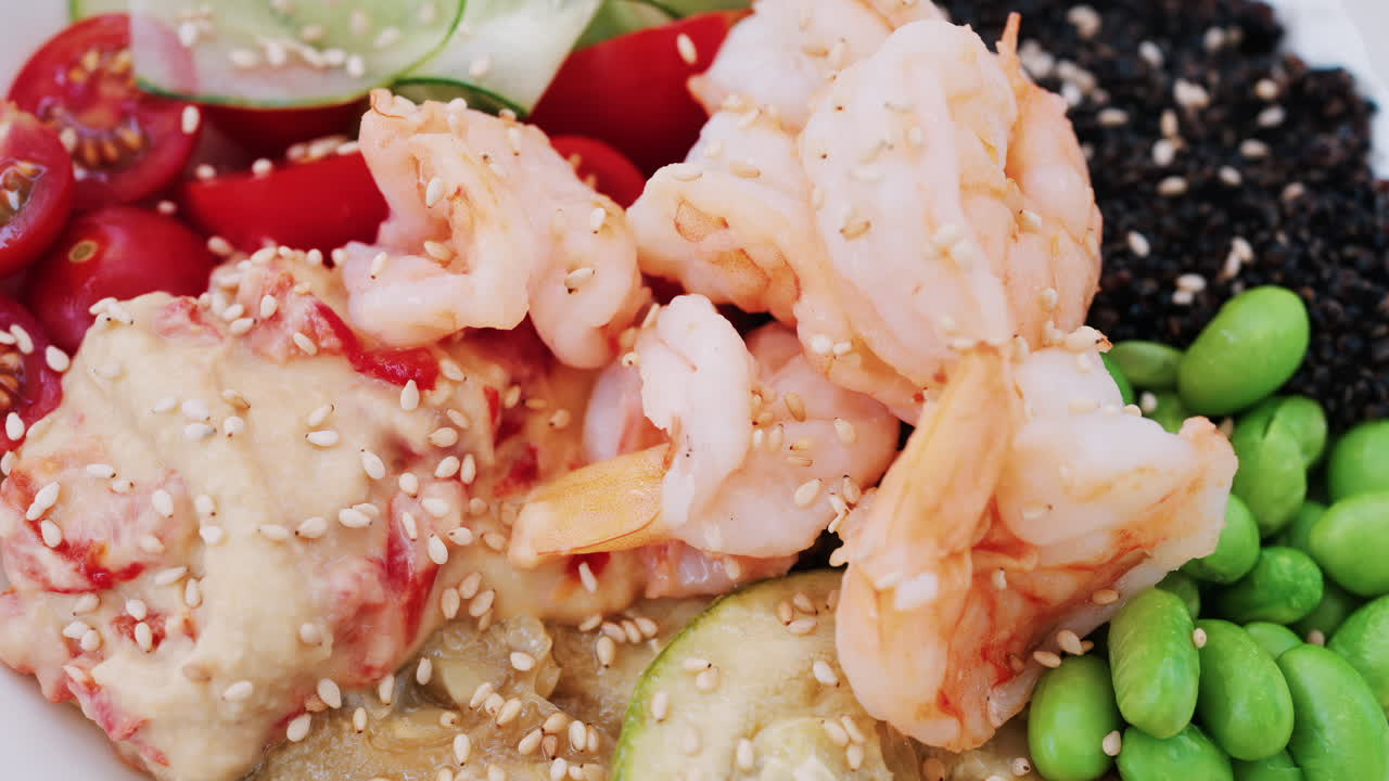 Healthy shrimp bowl with tomatoes, quinoa, edamame, and zucchini