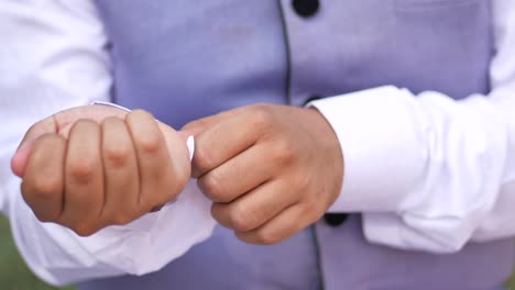 man buttoning his shirt close up