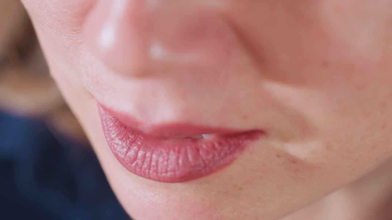 High angle view of wellness guide lips and lower face moving gently in calm conversation with client, blurred background offering soft, serene atmosphere in intimate coaching