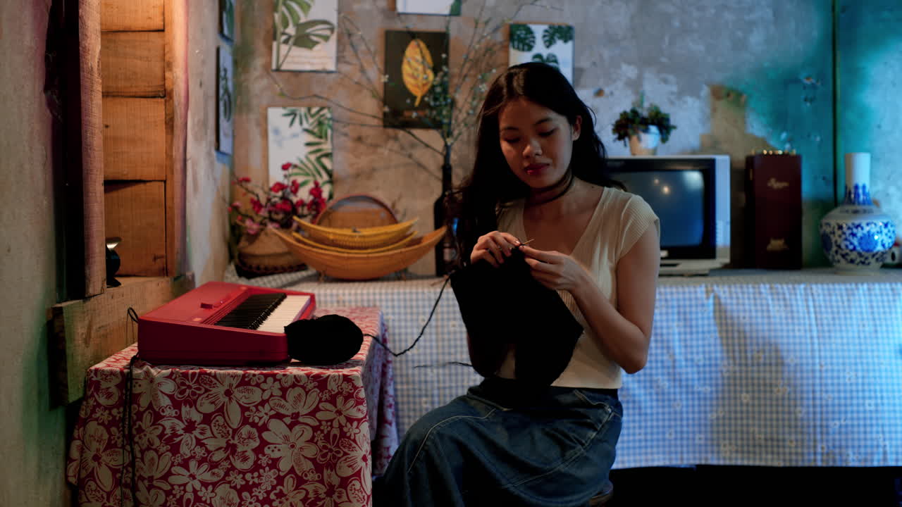 chica asiática haciendo ganchillo en casa, estática