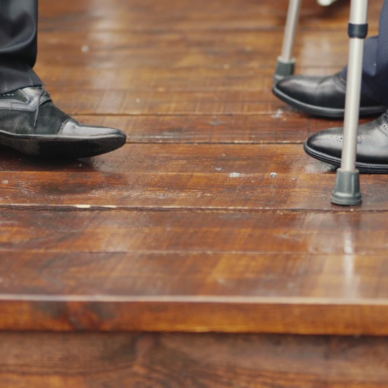 목발을 짚은 남자가 다른 남자와 의사소통을 한다