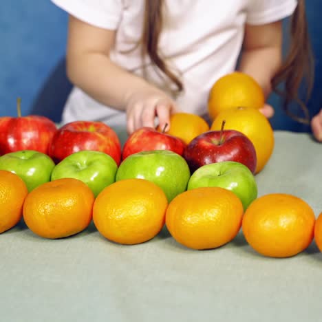 little girl with fruits on table
