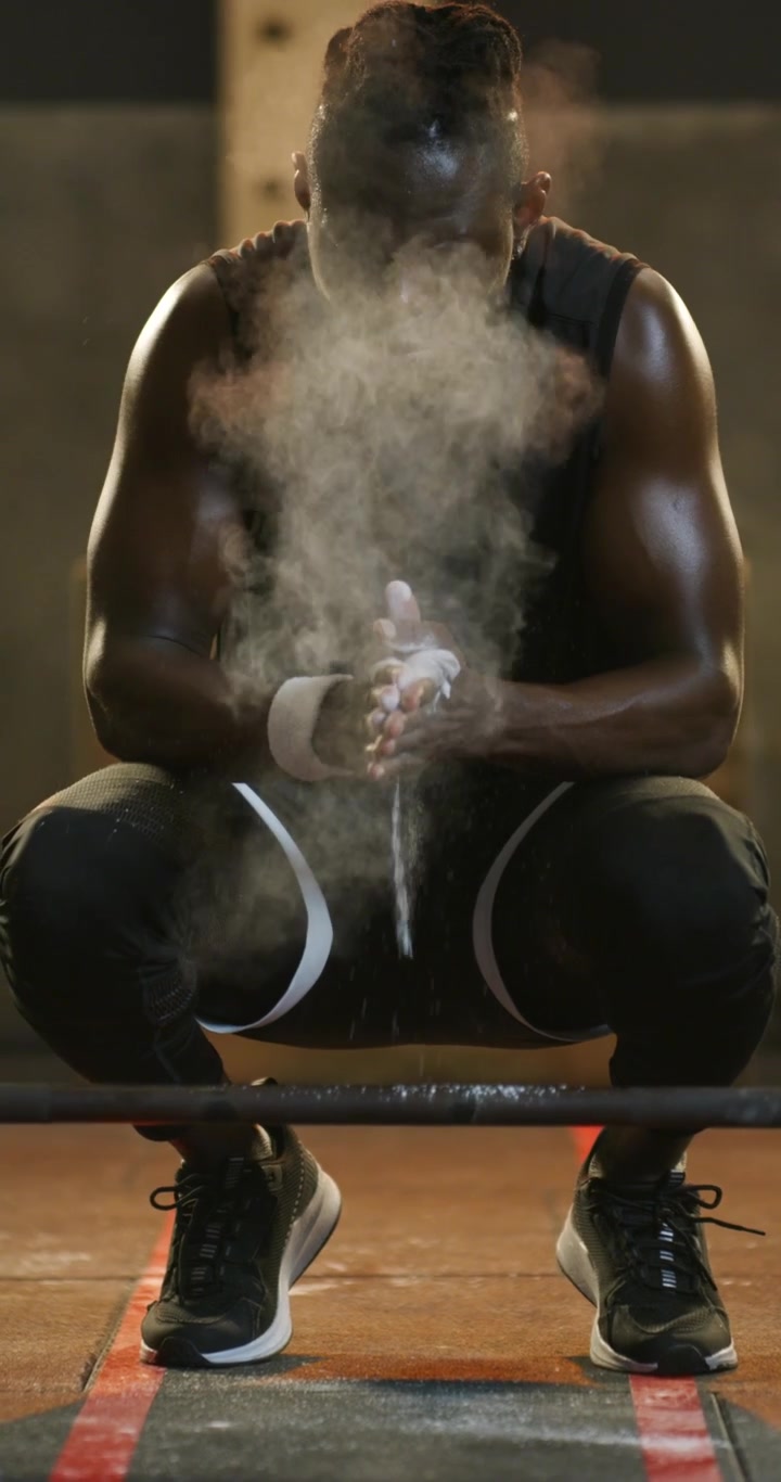 Muscular Athlete Applying Chalk and Performing Overhead Barbell Press