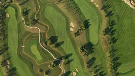 aerial view of a golf course with beautiful abstract patterns, sand traps, trees and lakes