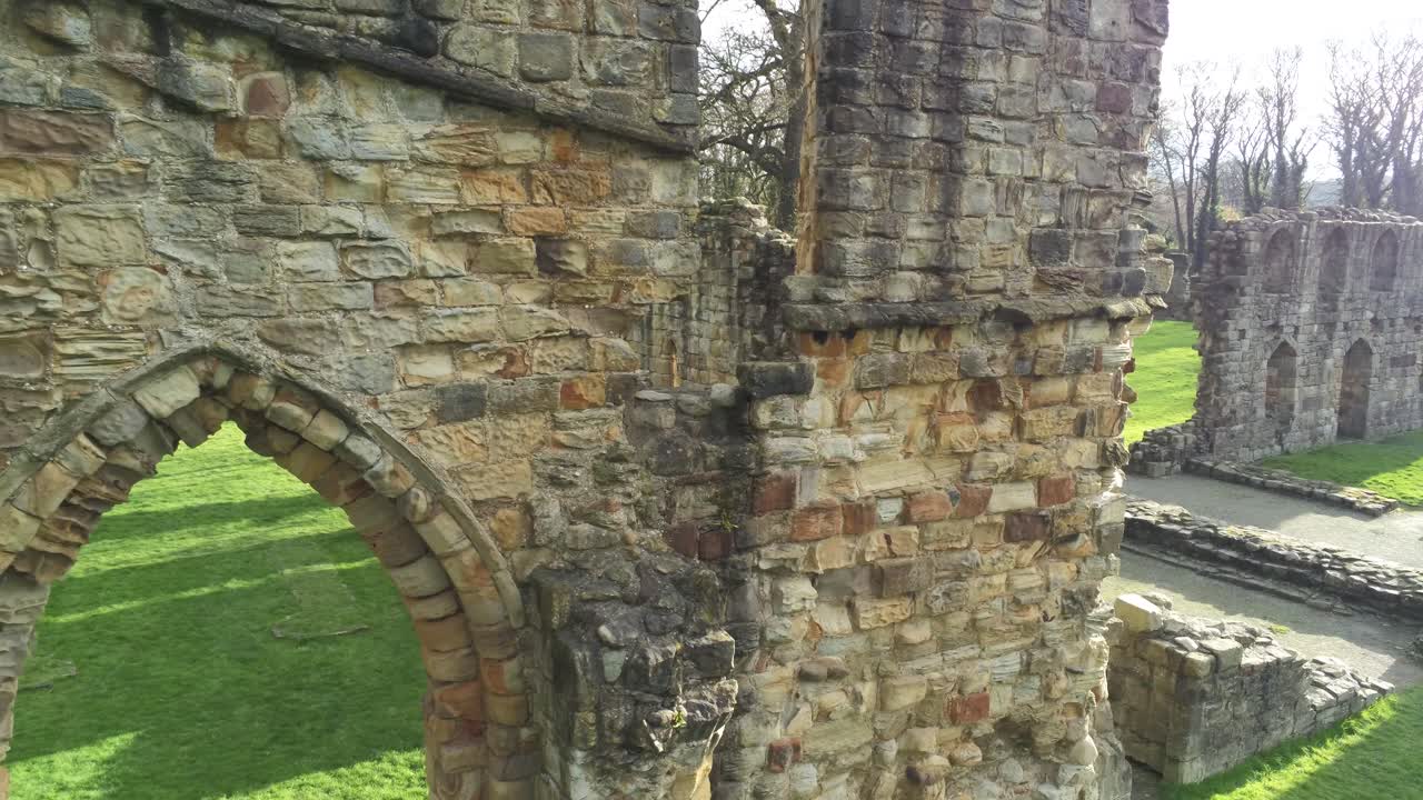 Abbazia di Basingwerk, punto di riferimento medievale, rovine gallesi abbandonate. Vista aerea con carrello lento a sinistra e primo piano.