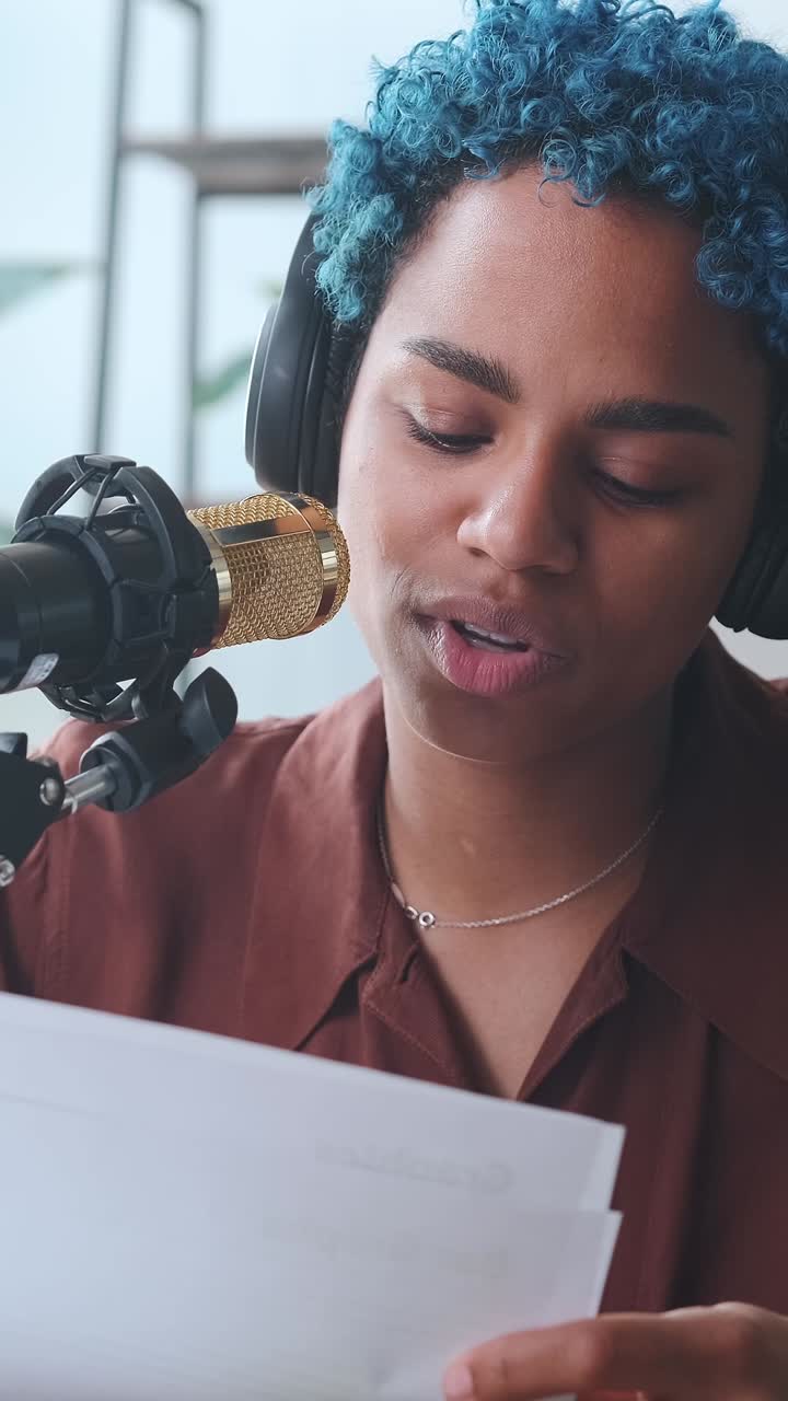 Young professional african american woman announcer reads news into microphone