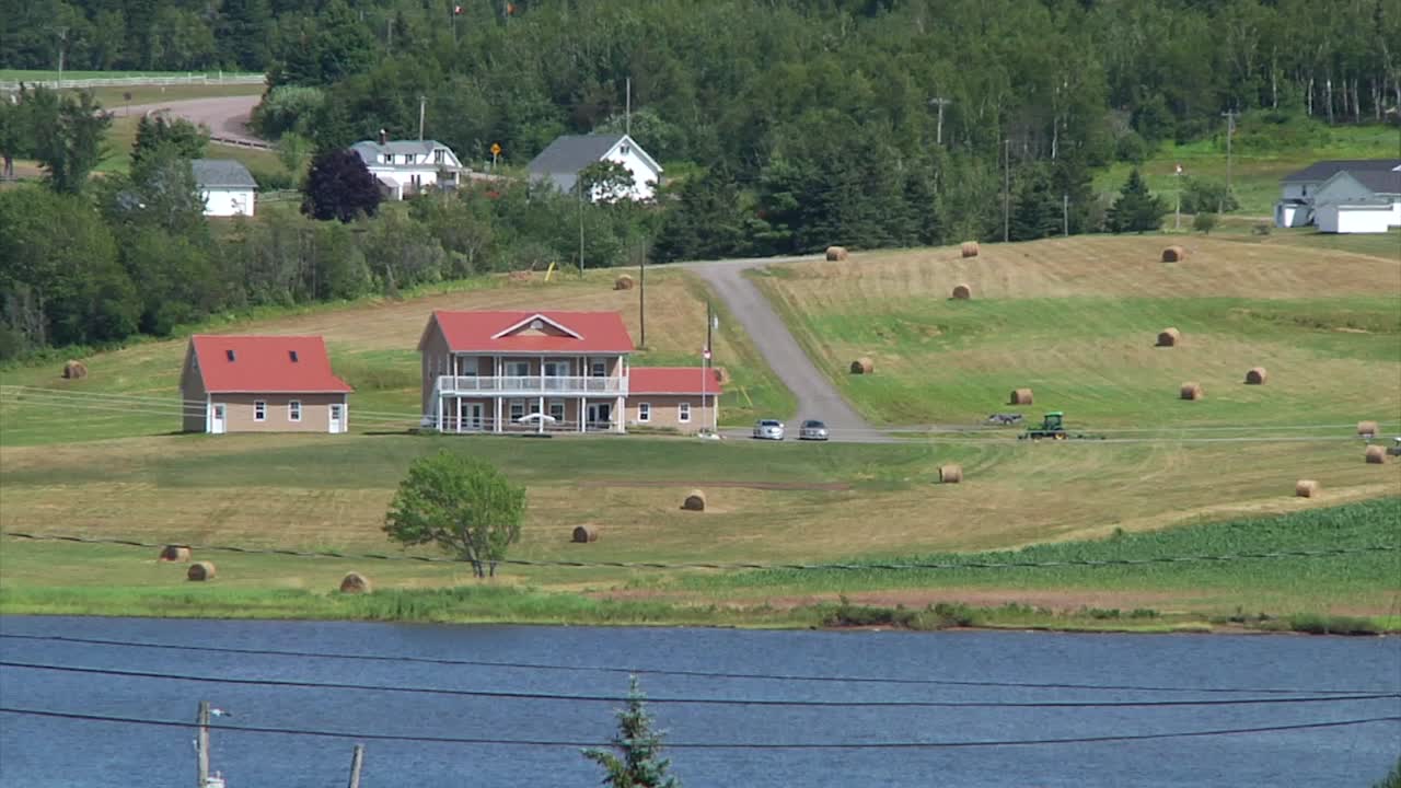 снимка дома, окруженного балами сена возле реки буктуш в сент-мари-де-кент, нью-брансуик, канада