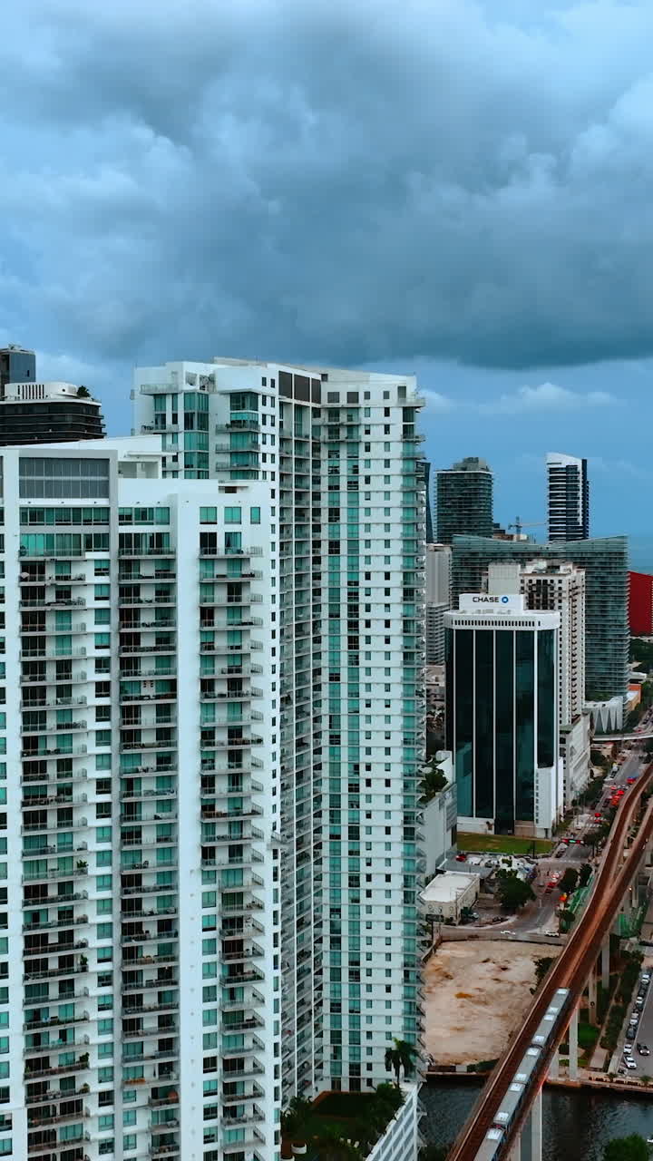 High-rise blocks of flats in the area of Miami, Florida, USA. Heavy clouds above the buildings. Vertical video
