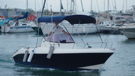 a person driving a motorboat in a marina