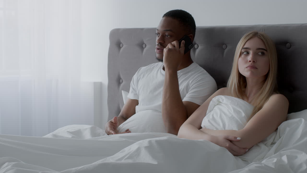 una pareja discutiendo en la cama.