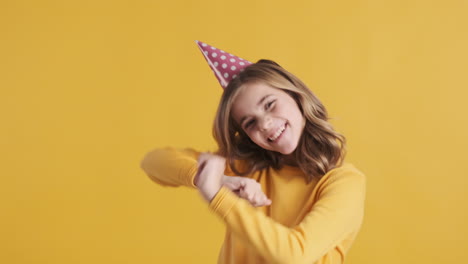 Teenage-Caucasian-girl-wearing-a-party-hat-and-dancing.