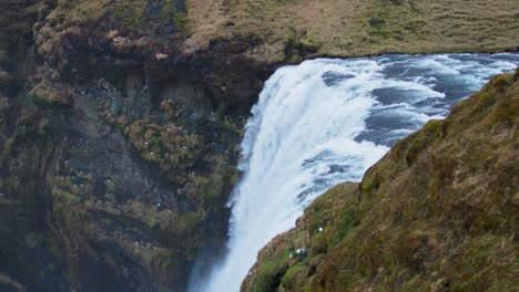 antiguo borde de la costa con la cascada de skogafoss cayendo desde el acantilado, islandia